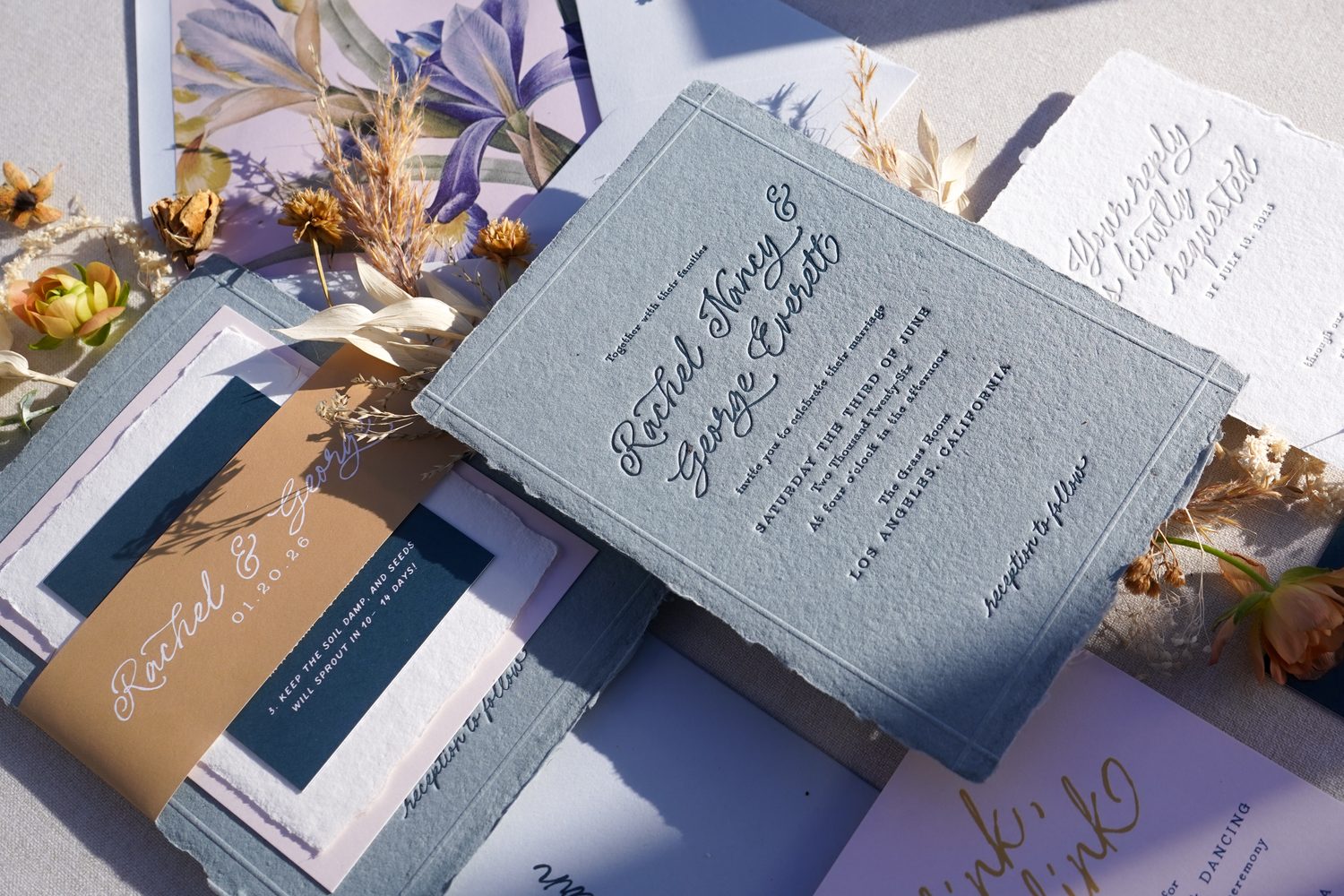playful, blue wedding invitations with calligraphy and blind emboss border